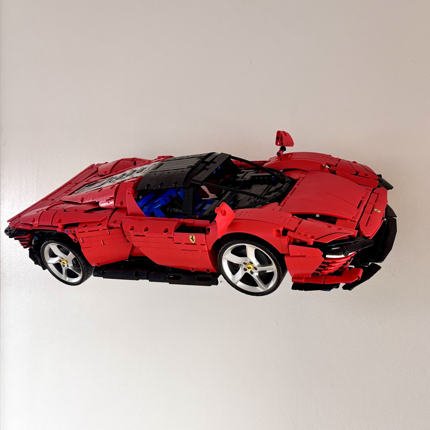 Horisontal væg-holder til LEGO® 42143 Ferrari monteret på væg i 30 graders udstilling
